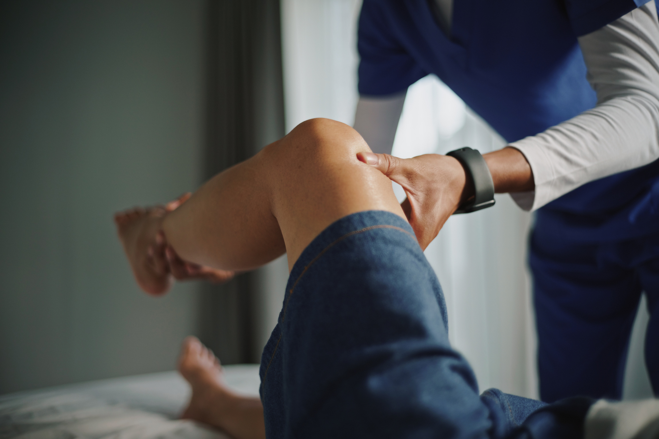 Physical therapist examining knee and leg. Massage sportif Kinésport